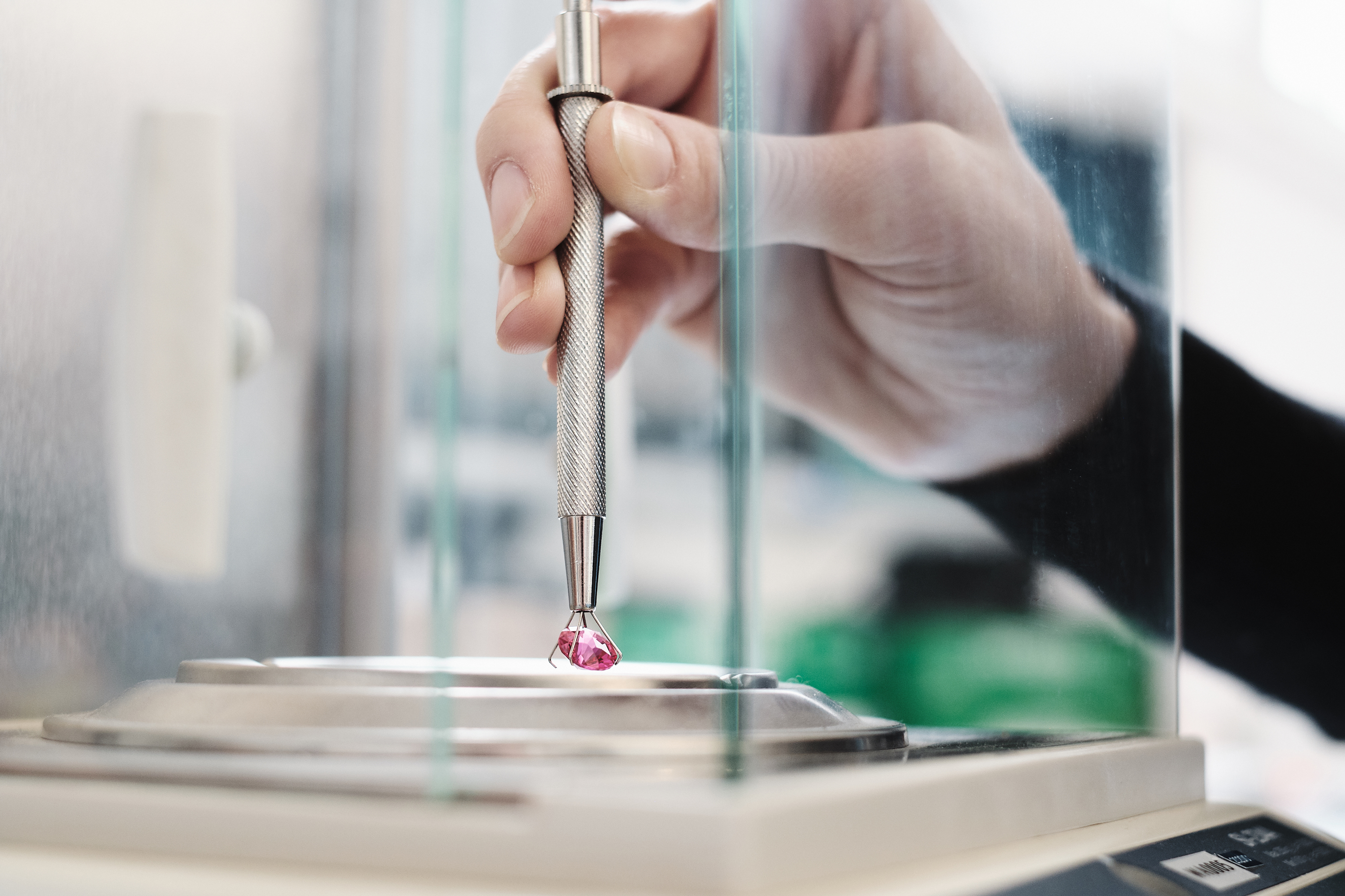 Ein Schleifer prüft die Qualität eines Edelsteins